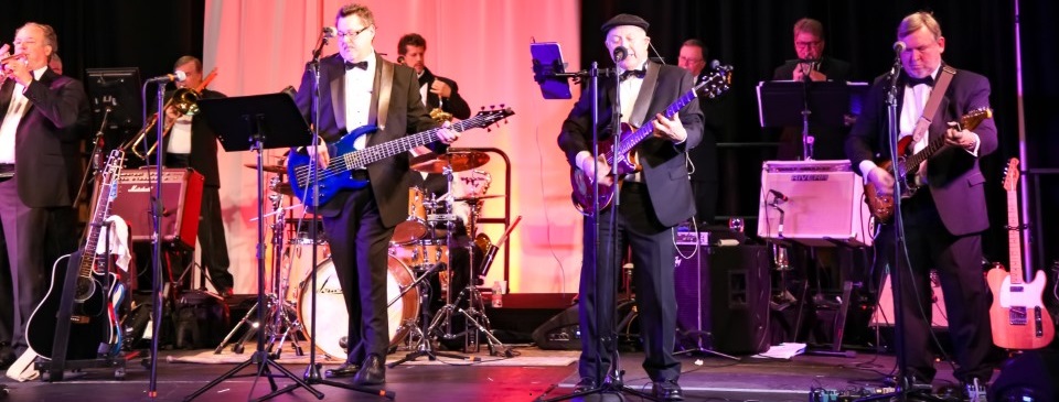 Nine band members performing on stage.